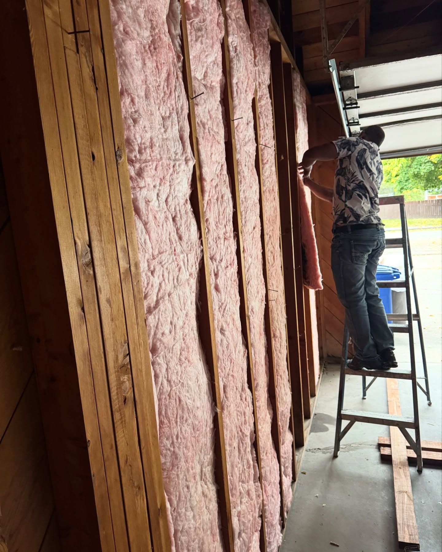Woman in straw hat smiles, holding wine glass near a lake.