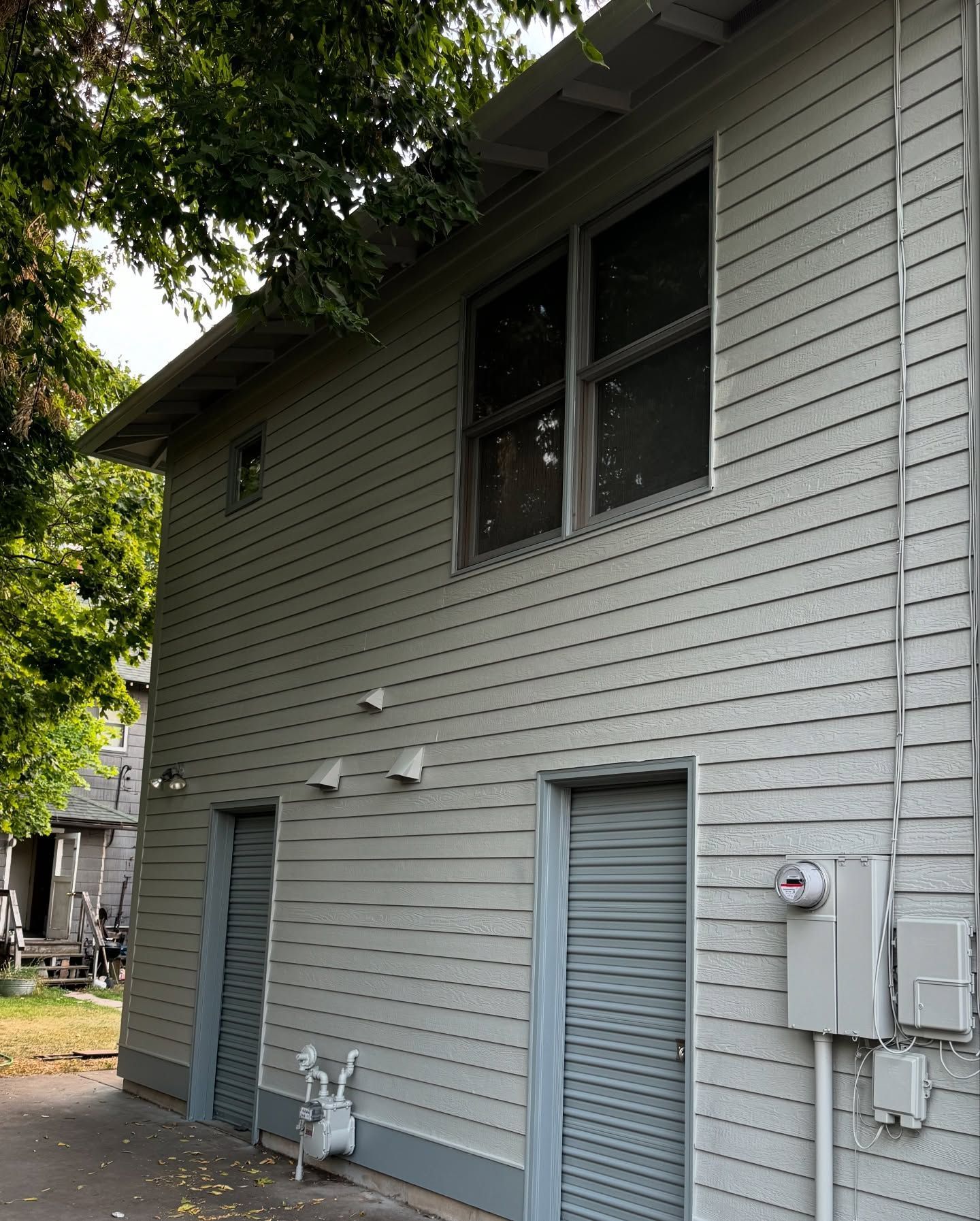 Woman in straw hat smiles, holding wine glass near a lake.