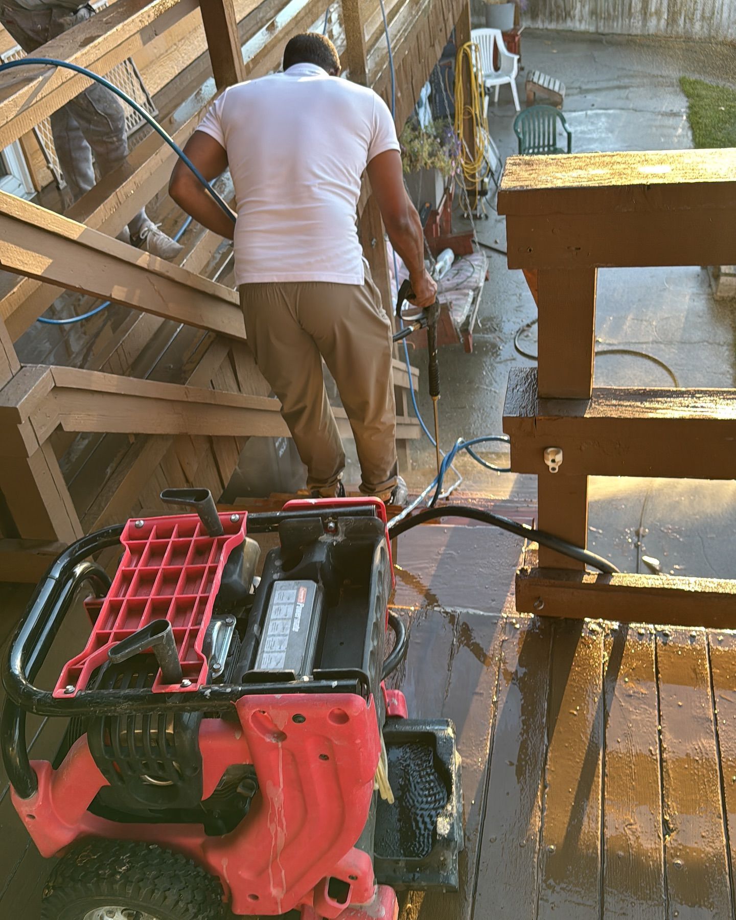 Woman in straw hat smiles, holding wine glass near a lake.