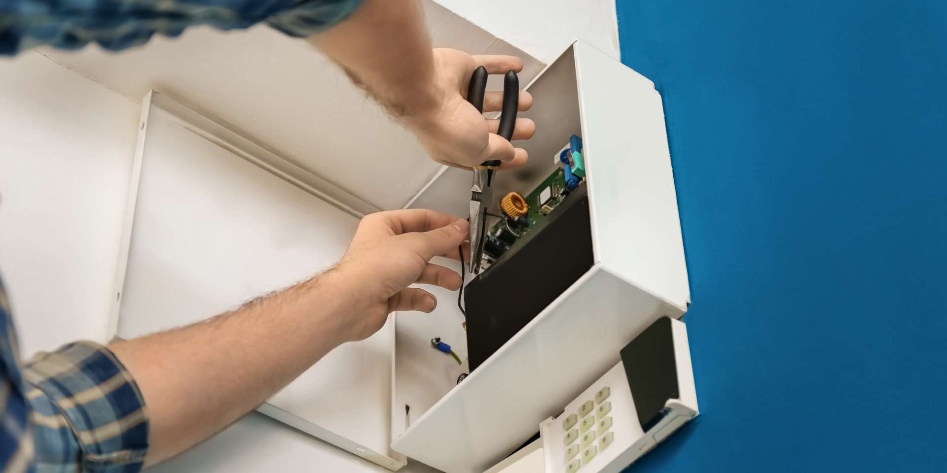 Man Installing a home alarm system.