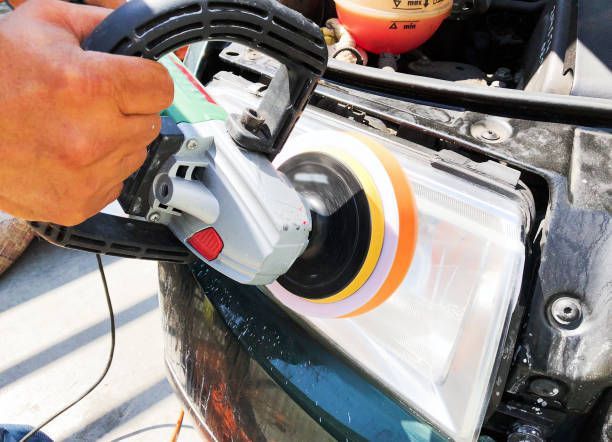Two men are installing a windshield on a car.