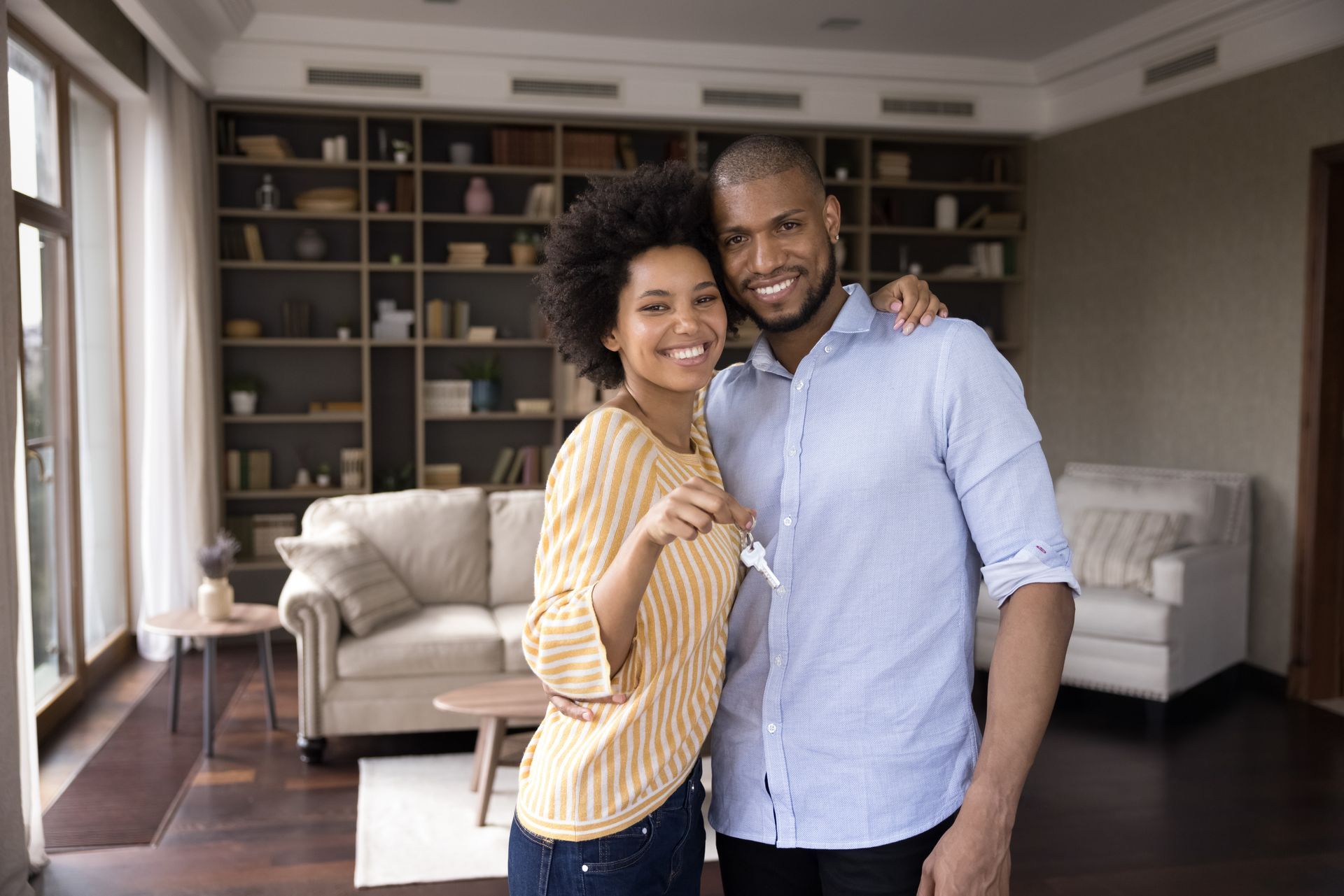A man and a woman are posing for a picture in their new home.