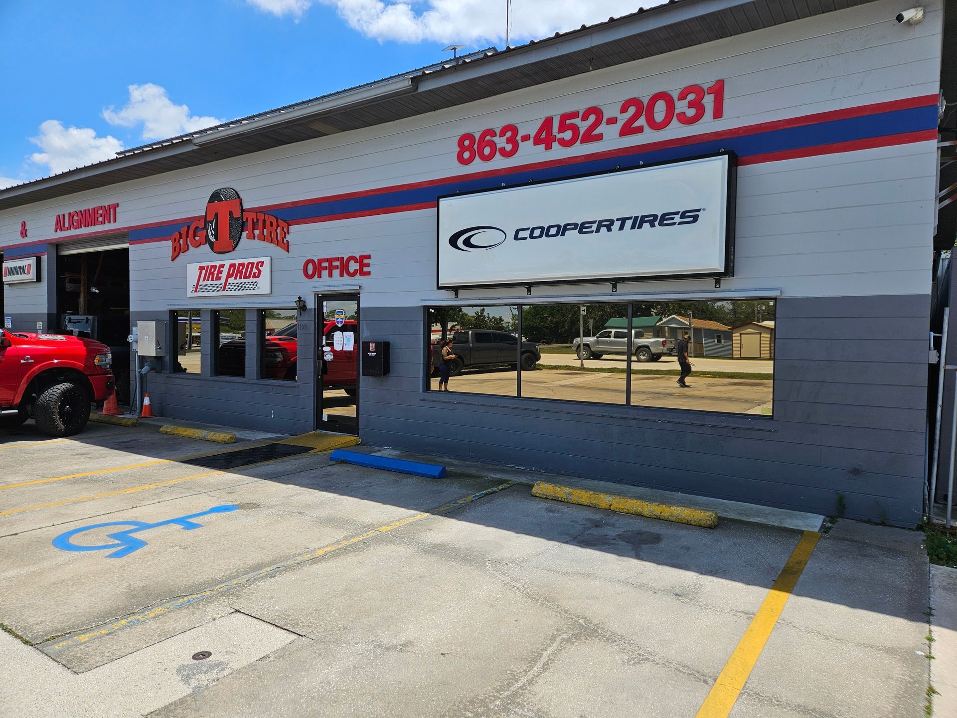 A red truck is parked in front of a tire shop