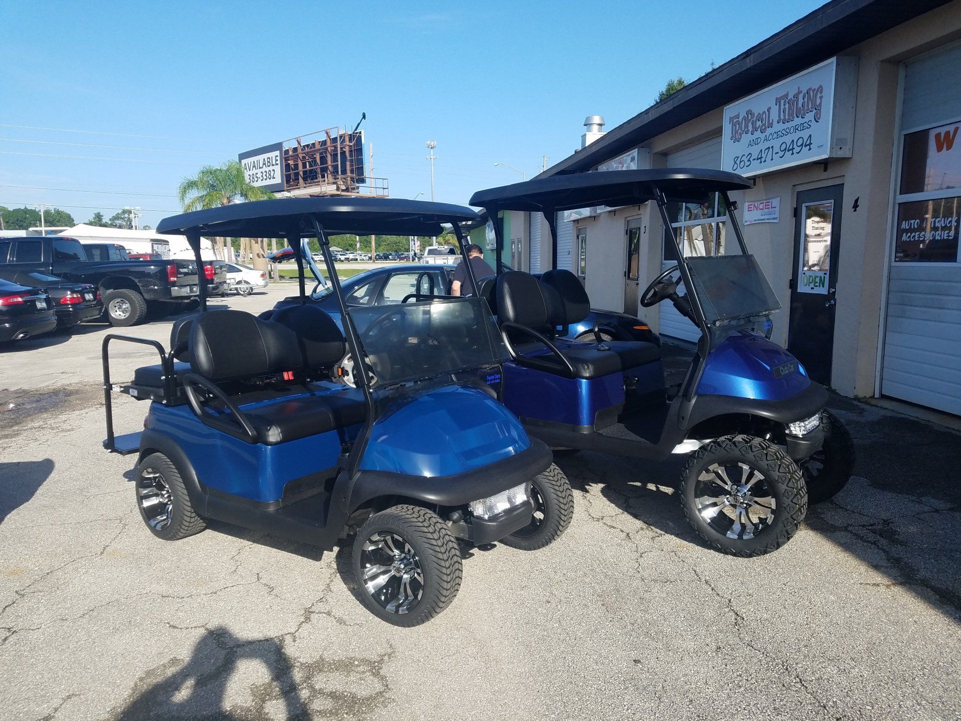 Two golf carts are parked in front of a building.