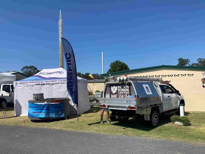 A Truck is Parked in a Grassy Area Next to a Tent — Matt King Plumbing & Septic Systems in Wingham, NSW