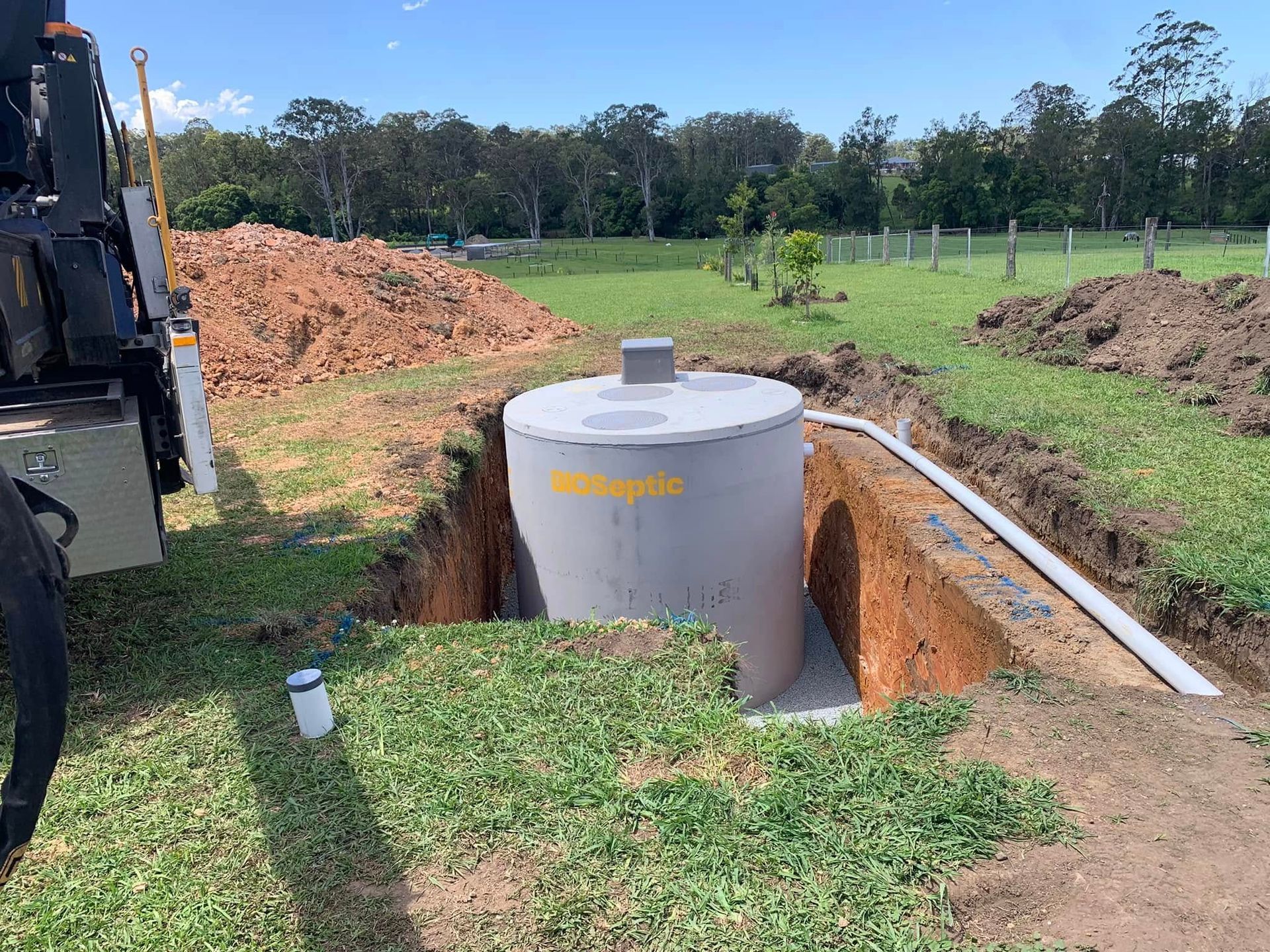 A Crane Is Lifting a Large Concrete Cylinder Into a Hole — Matt King Plumbing & Septic Systems in Taree, NSW
