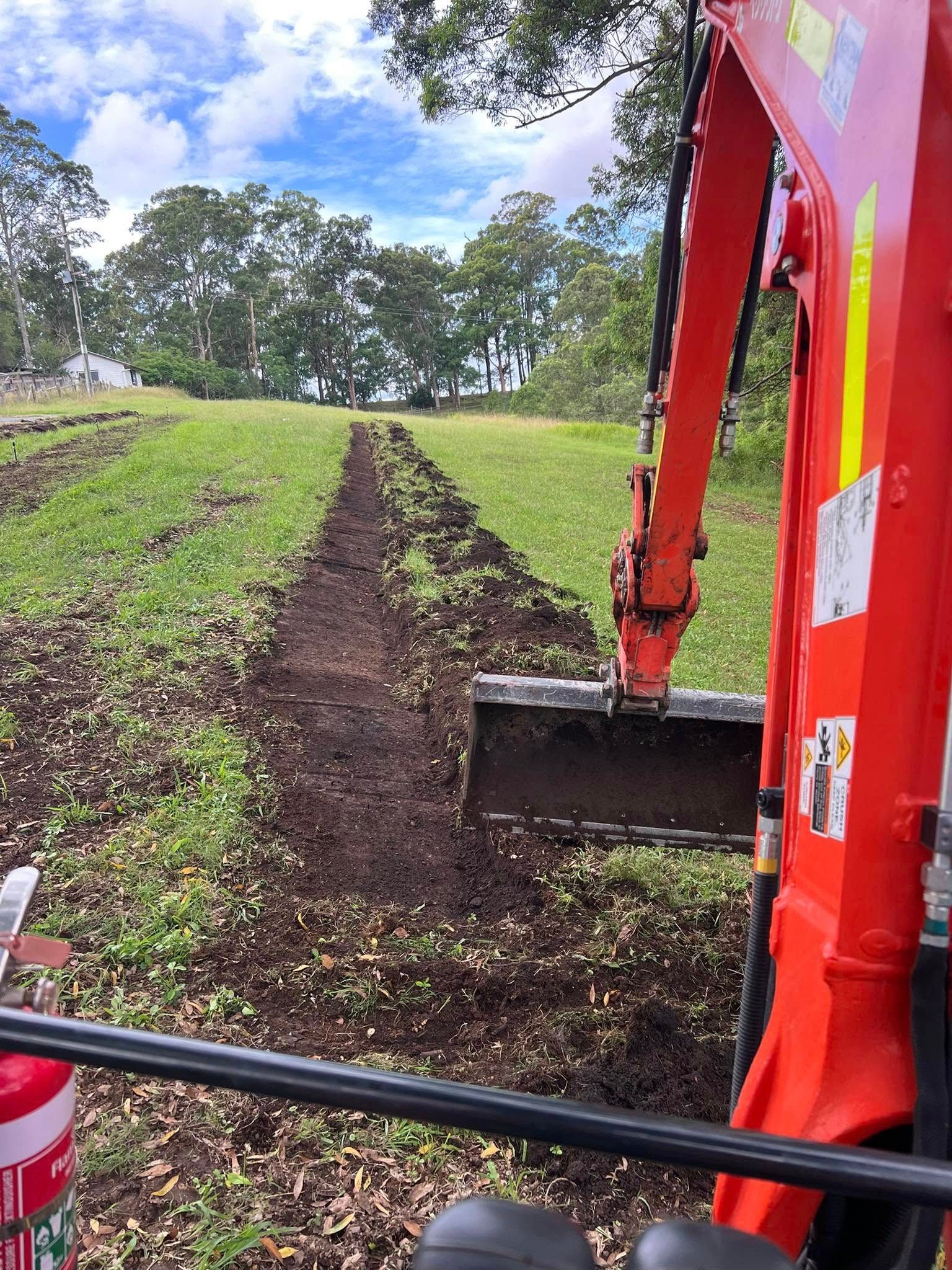 A Orange Digger Plowing A field ready for irrigation — Matt King Plumbing & Septic Systems in Taree, NSW