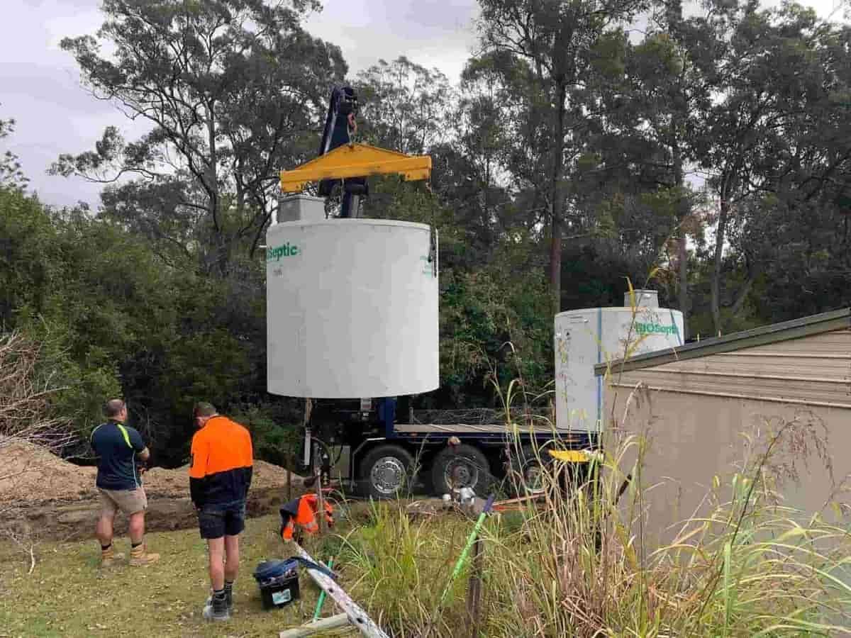 A truck is lifting a large white tank — Matt King Plumbing & Septic Systems in Taree, NSW