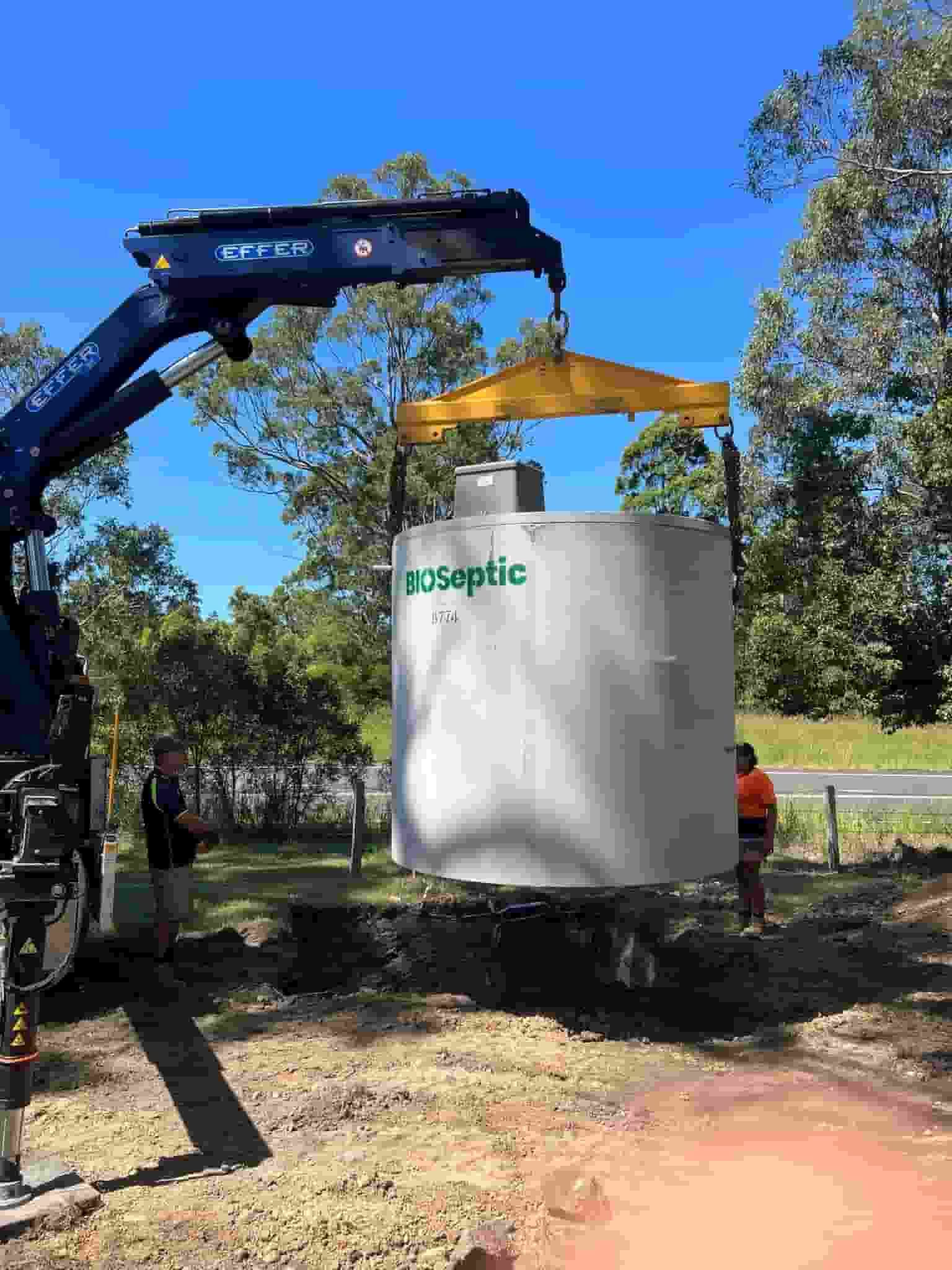 A Large Concrete Cylinder Is Being Lifted by A Crane — Matt King Plumbing & Septic Systems in Taree, NSW