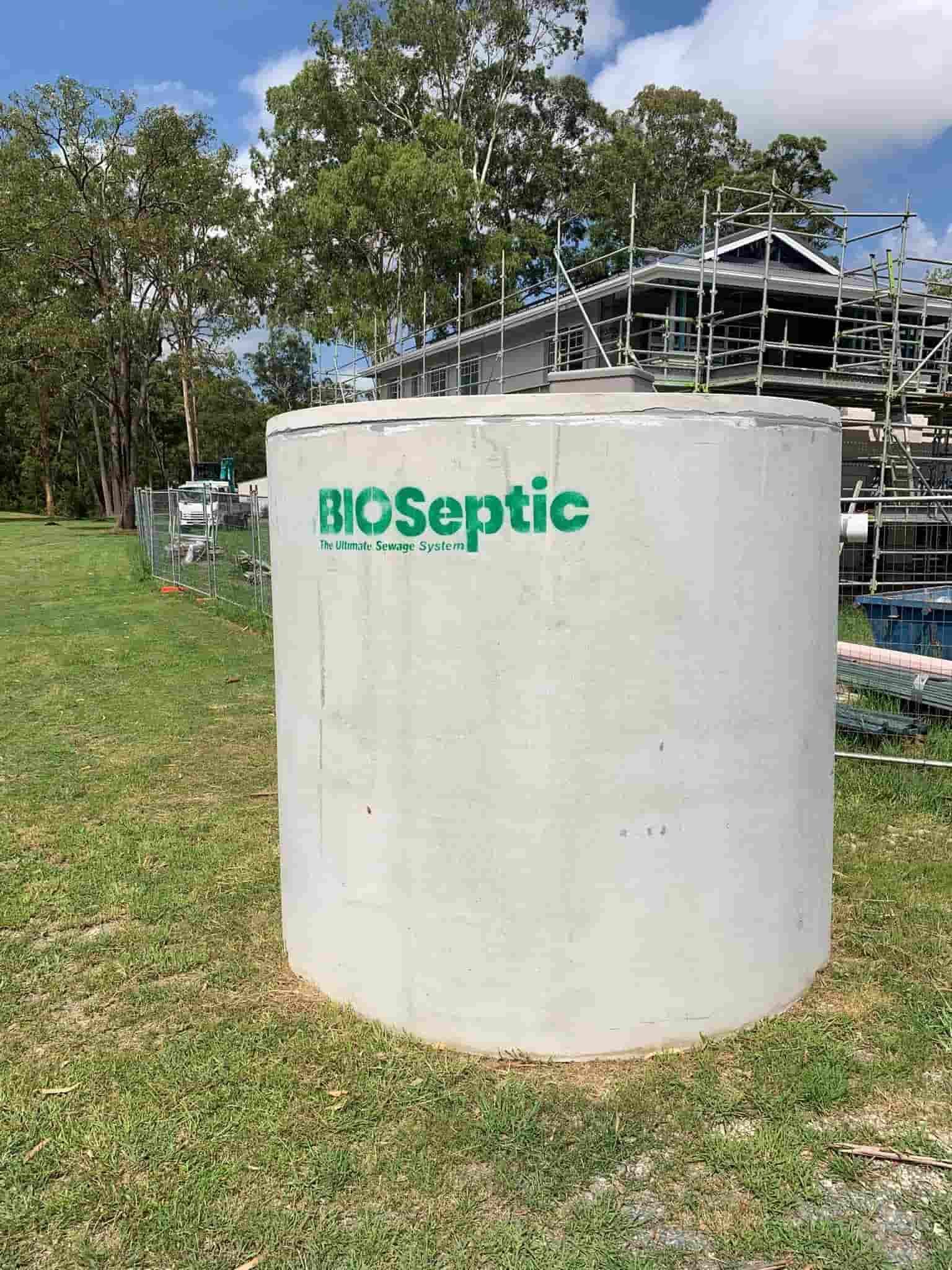 A Large Concrete Cylinder Is Sitting on Top of A Lush Green Field — Matt King Plumbing & Septic Systems in Taree, NSW
