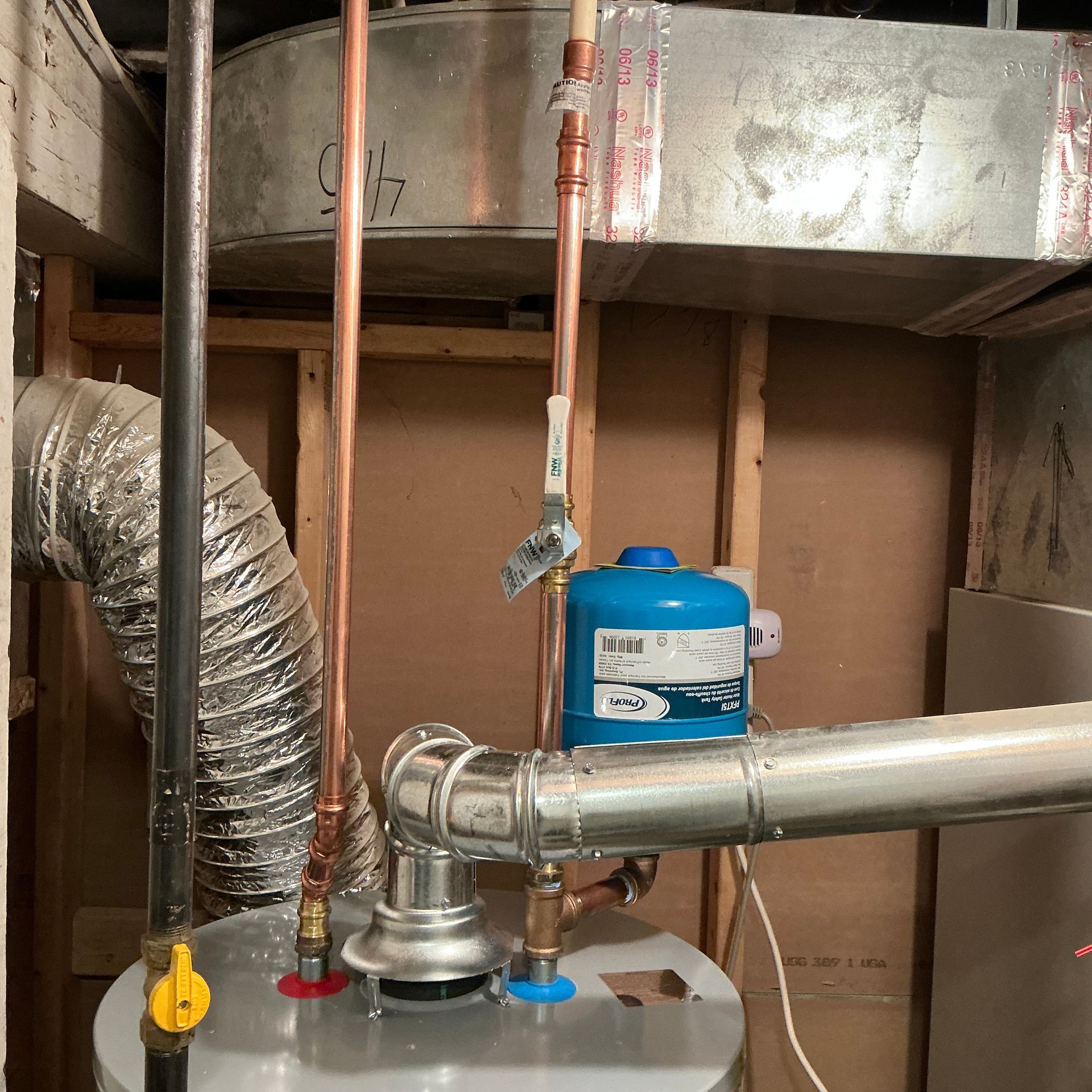 Water heater and related plumbing in a basement. Copper pipes, blue tank, and silver ducting are visible.