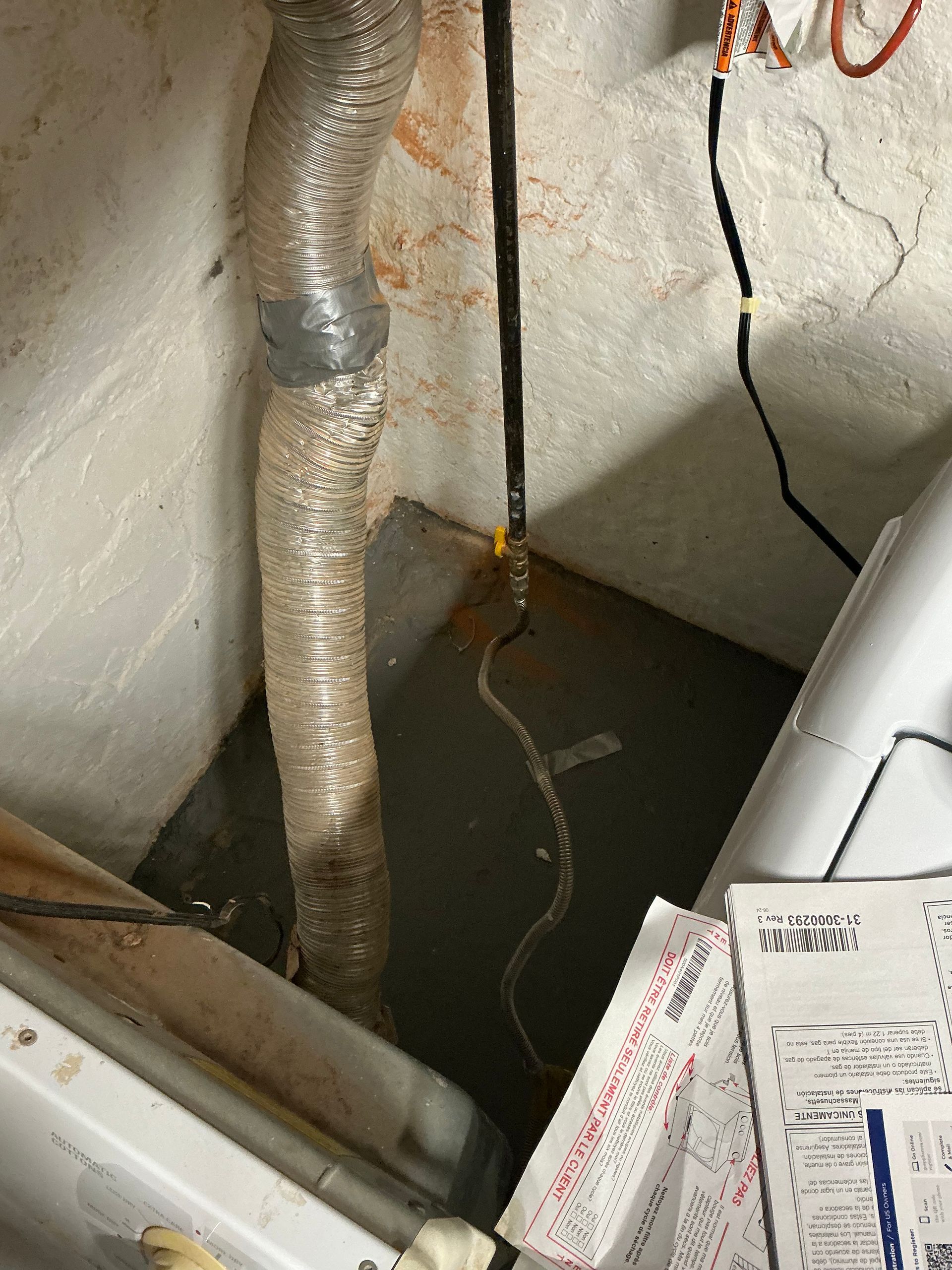 Laundry room with dryer vent, electrical wires, and appliances.