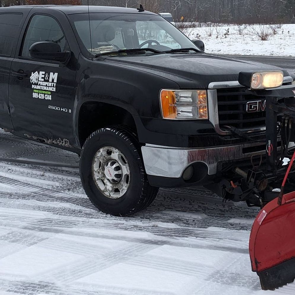 A black truck with a snow plow attached to it
