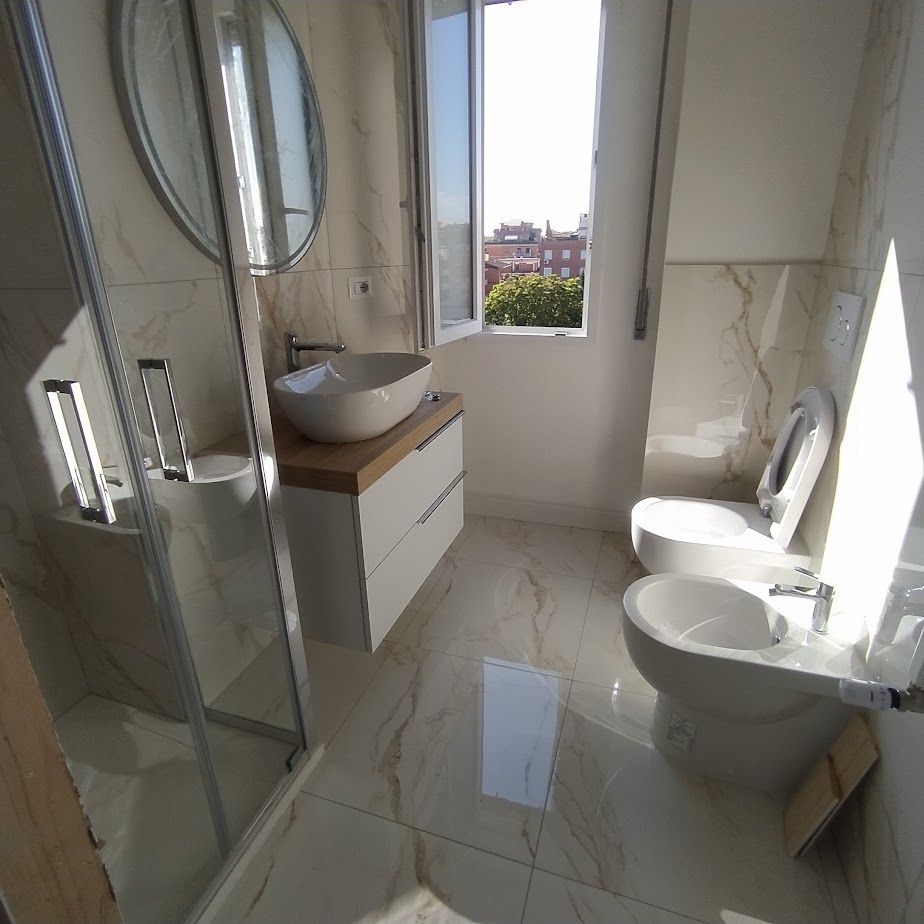 Bagno moderno con rivestimenti in marmo e sanitari sospesi