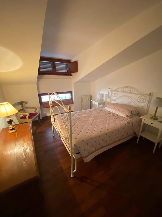 Camera con parquet e arredo essenziale – ristrutturazione casa Olgiata