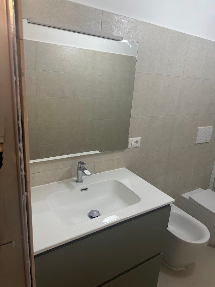 Doccia walk-in con soffione a pioggia e rivestimento effetto pietra