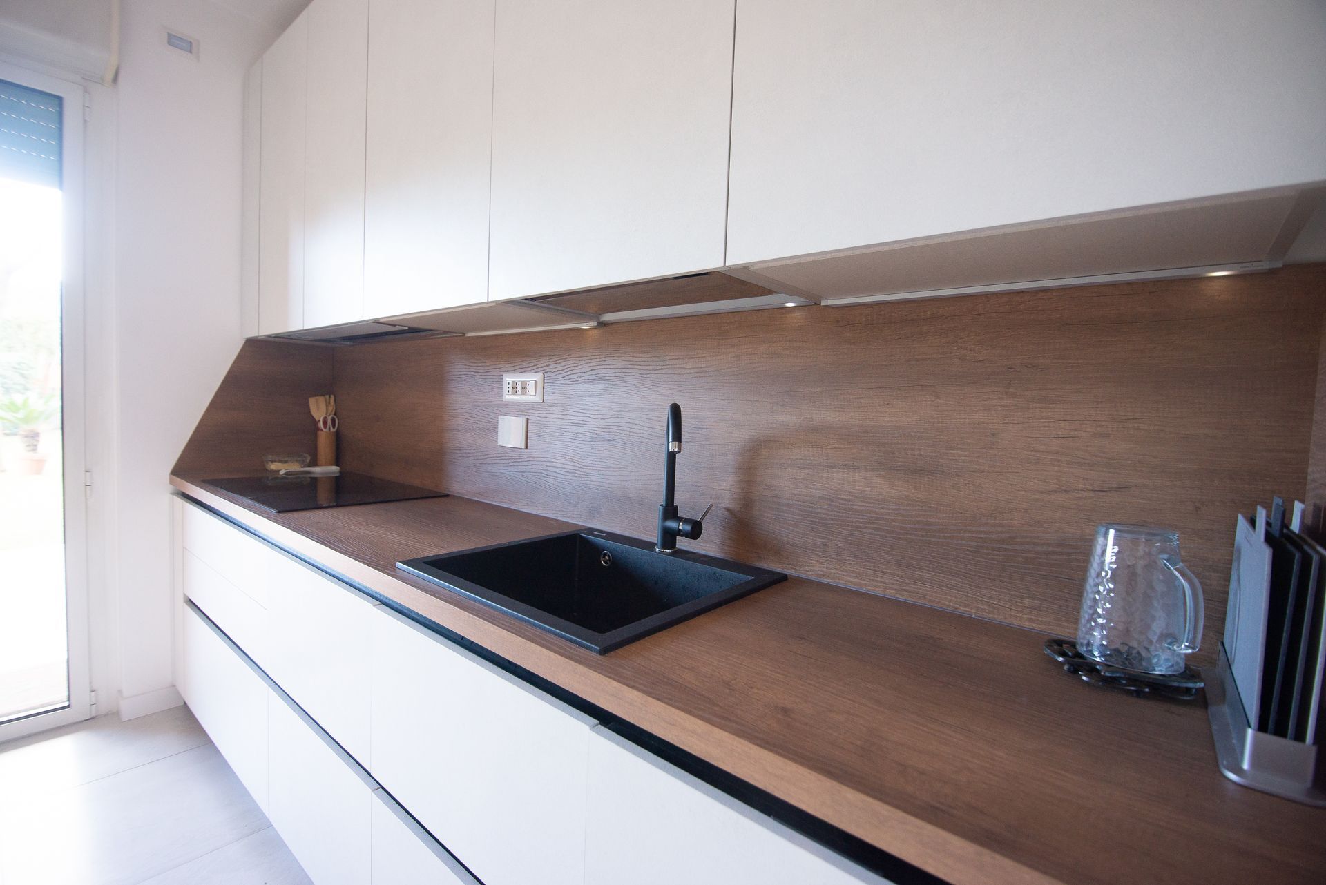 Cucina open space con finiture moderne e isola centrale, ideale per uno stile di vita funzionale e contemporaneo