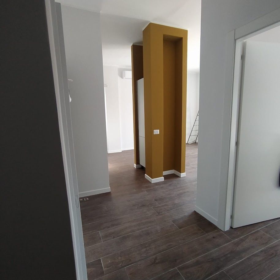 Pilastro decorativo giallo oro nel soggiorno ristrutturato