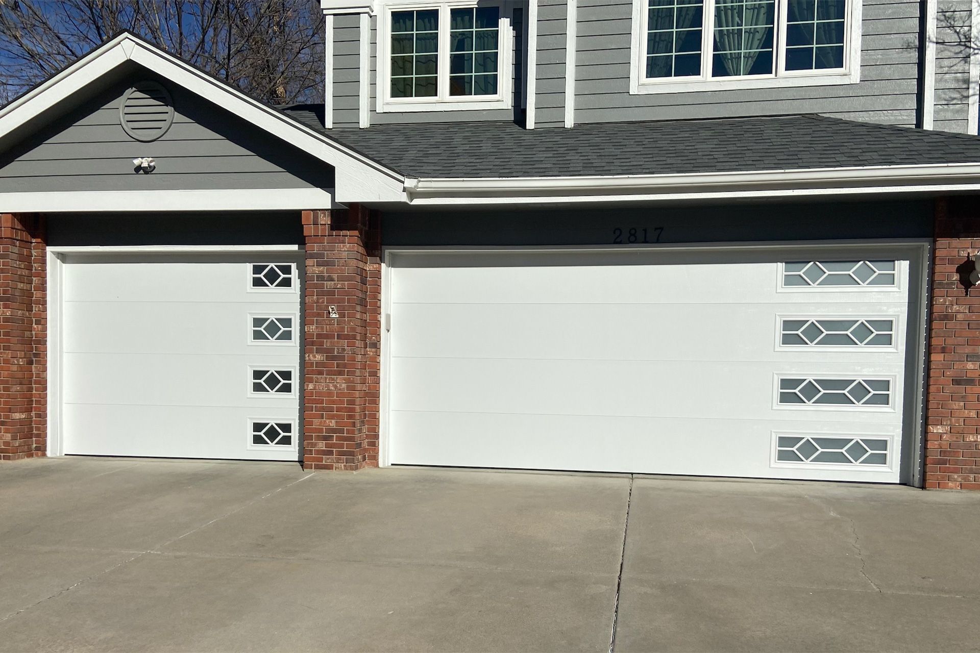 A black truck is parked in a garage next to a garage door opener.