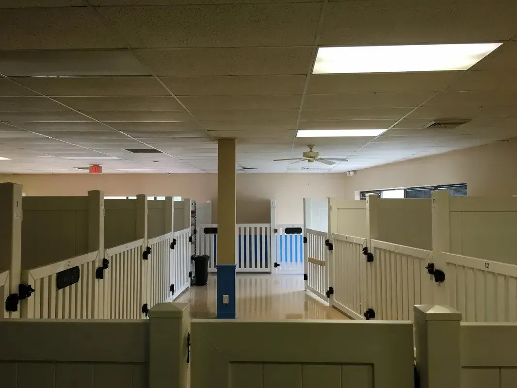 A room with a lot of white fences and a ceiling fan.