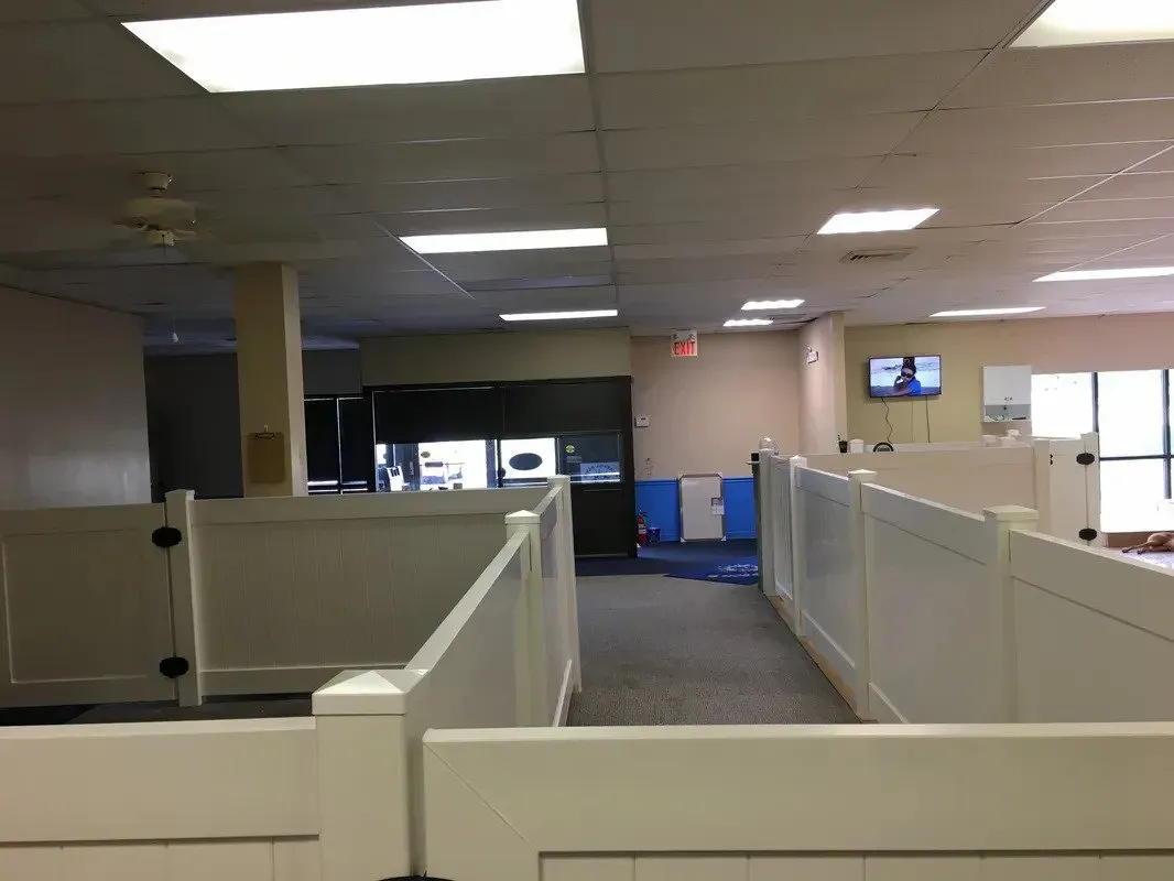 A hallway with cubicles and a tv on the wall