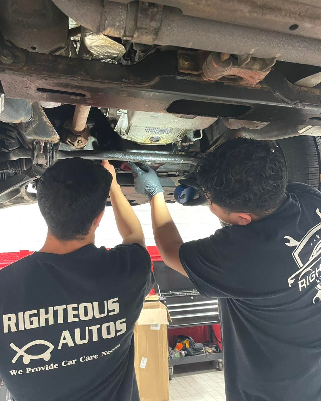 Two mechanics working under a vehicle | Righteous Auto Care