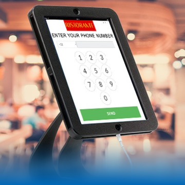 A tablet is sitting on a stand in a restaurant.