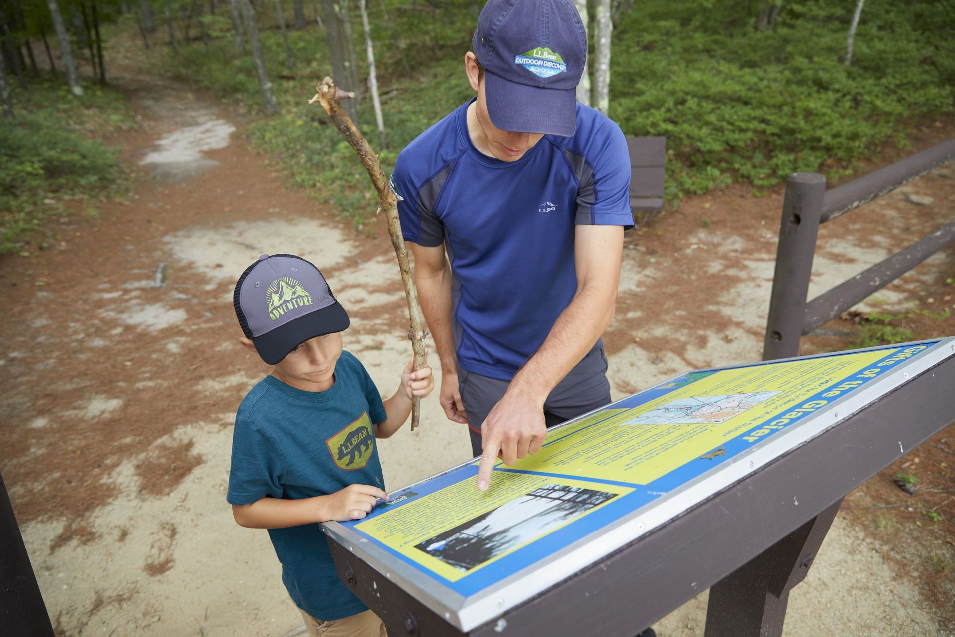 An instructor points out information on a sign to a youth participant.