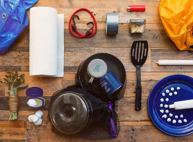 Various camping accessories including a skillet, spatula, and candles.