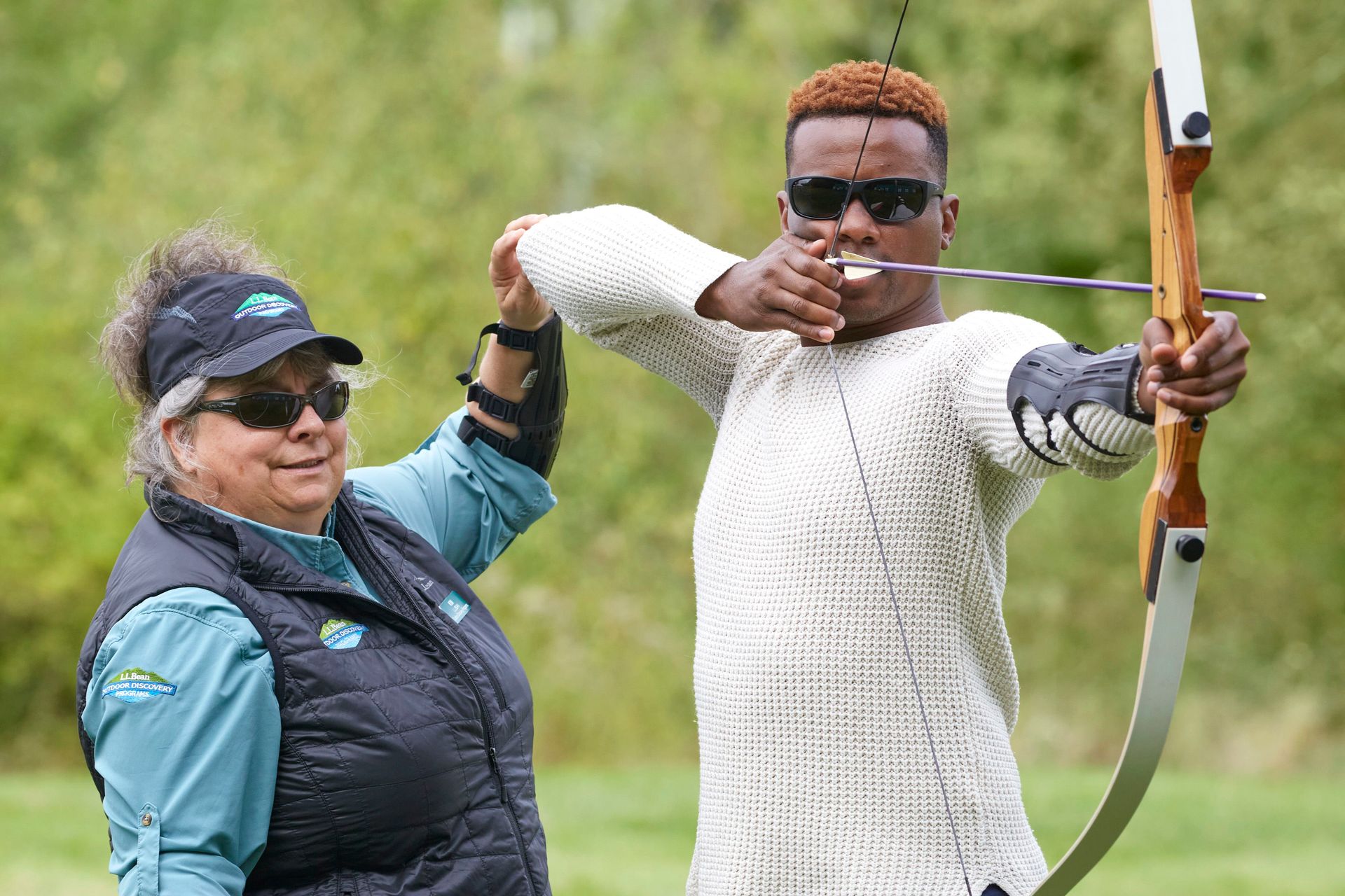 instructor helping participant with archery form and technique