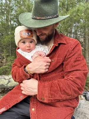 A man holding a baby against his chest, while wearing an L.L.Bean 1912 Heritage Lined Shirt Jac.
