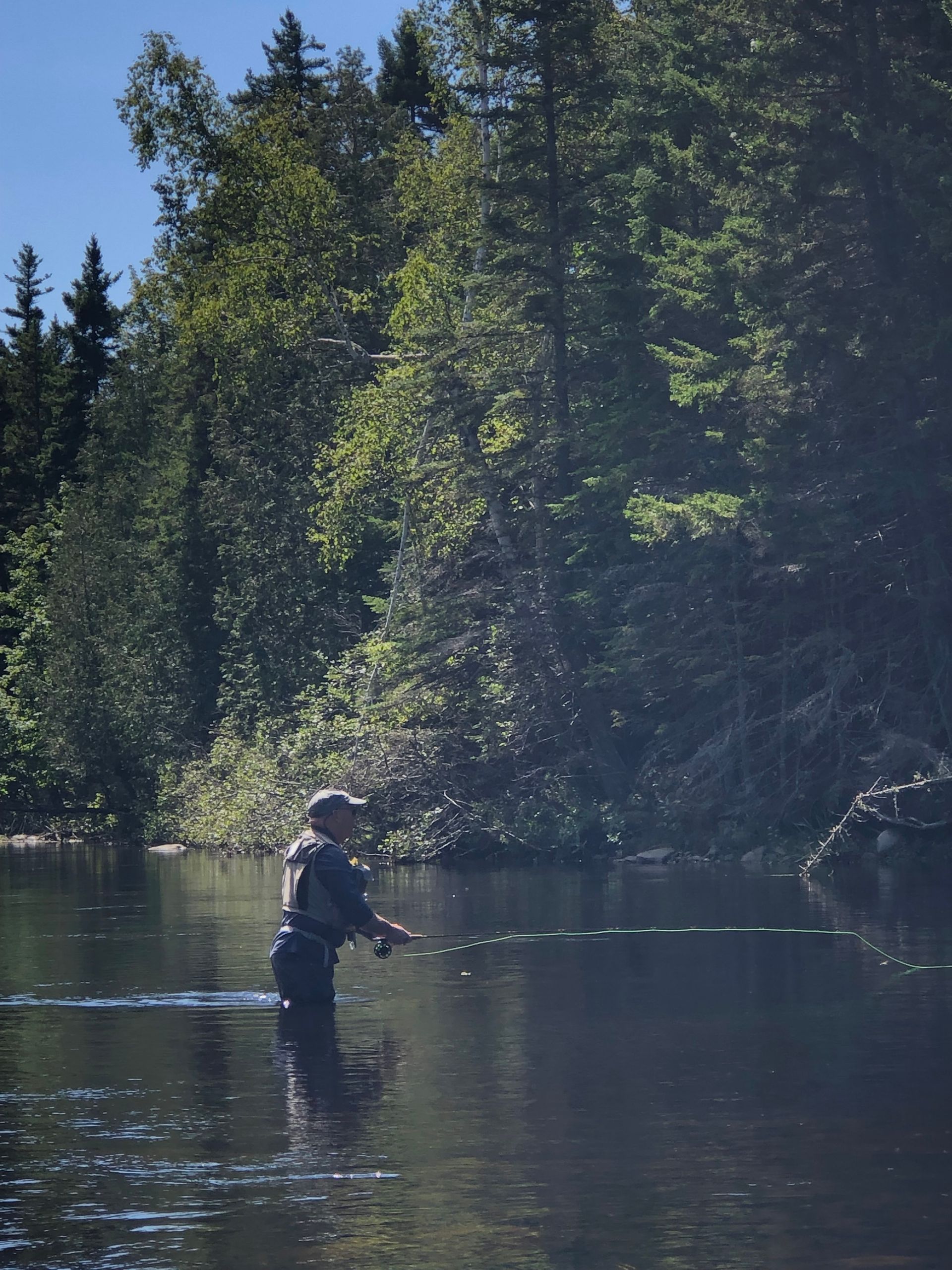 close up of person standing in a river fly fishing
