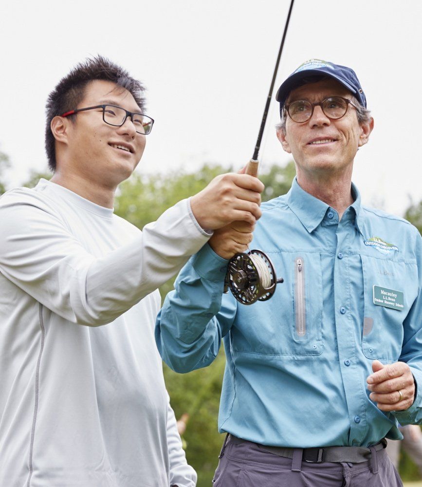 Young man learning to fish from an instructor
