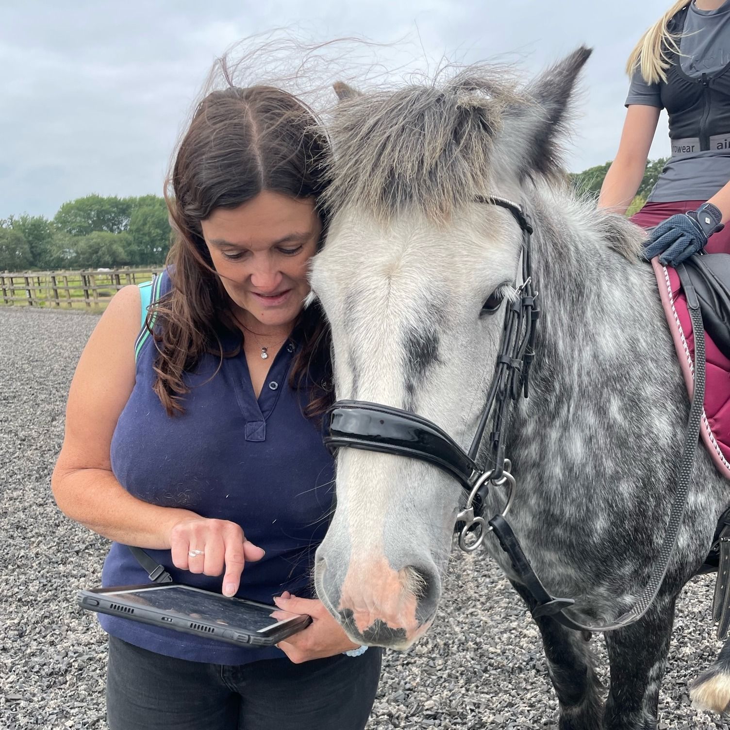 Sarah Wood of Flying Hooves showing a horse the iPad screen during an appointment