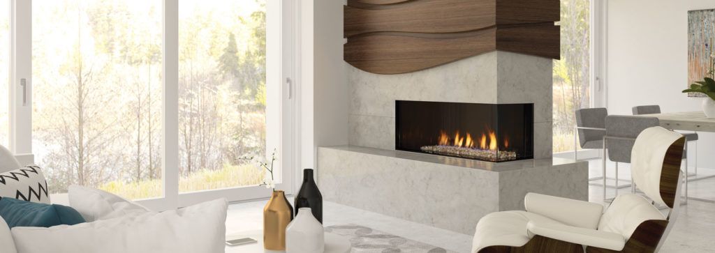 A corner fireplace in a living room area inside a wall feature helps separate this bright room.