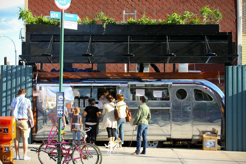A group of people standing outside of a building with a sign that says ' sling ' on it
