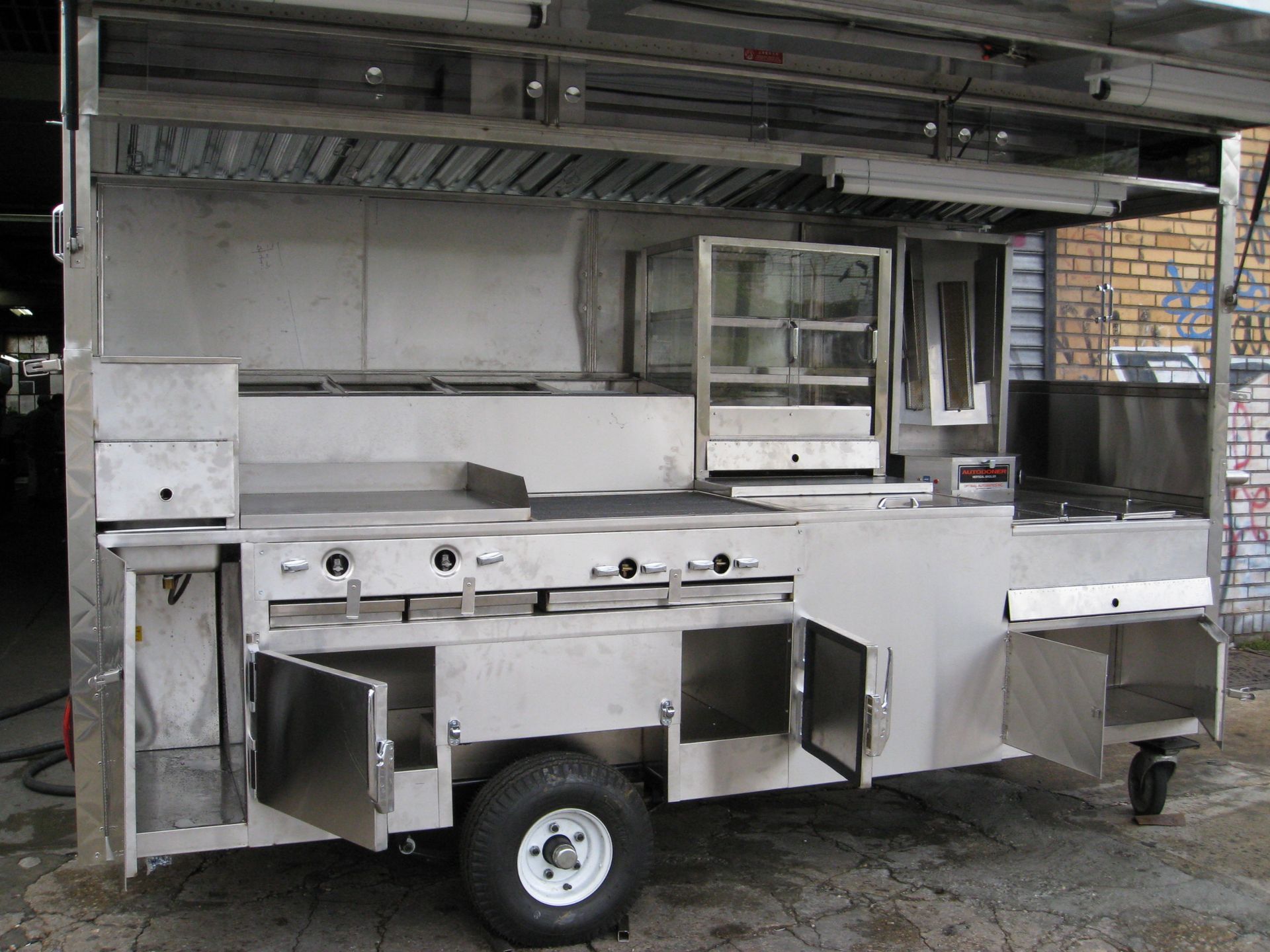 A stainless steel food truck with the doors open