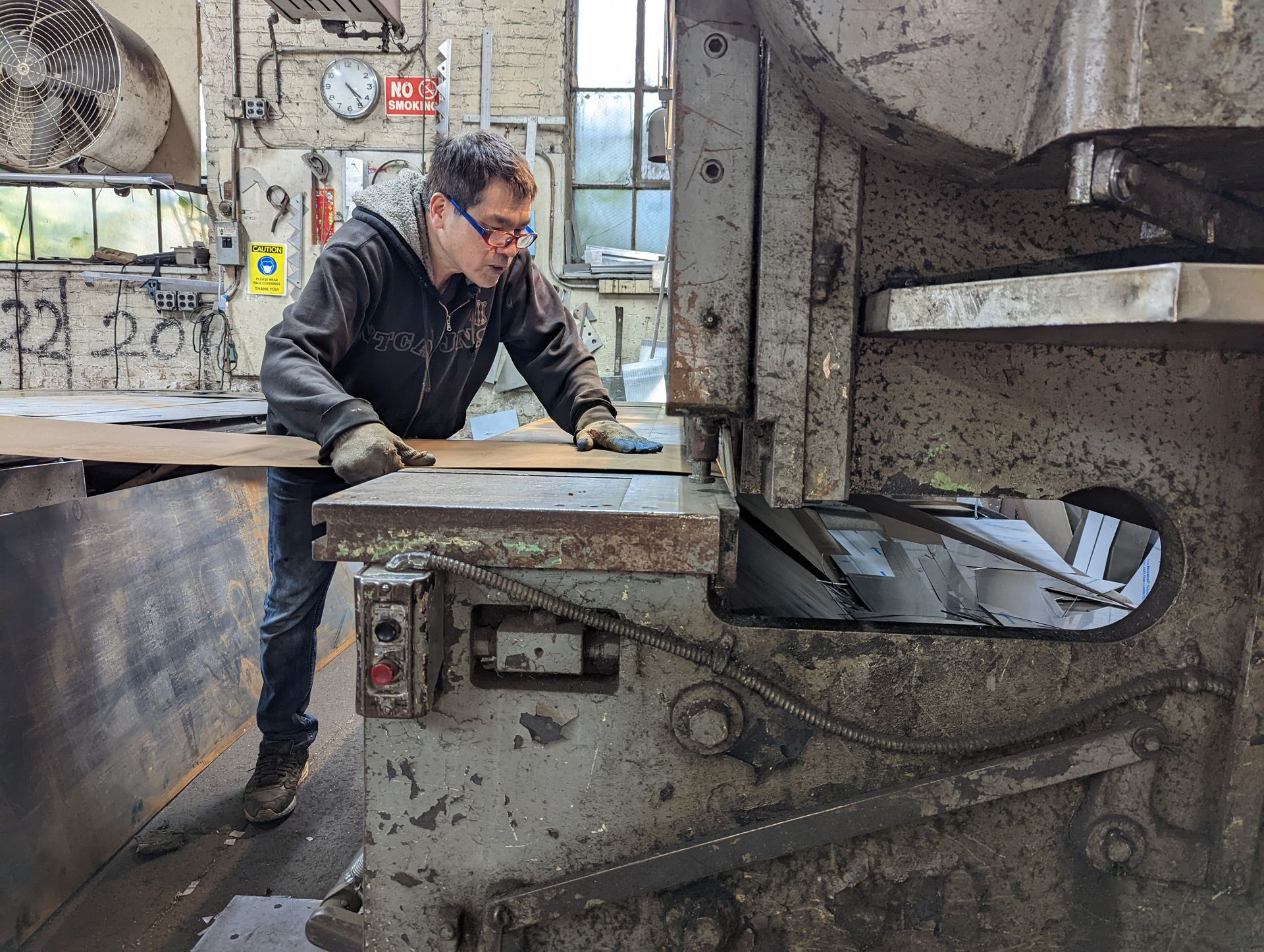 An expert stainless steel craftsman at Shanghai Mobile Kitchen Solutions cuts materials to spec.