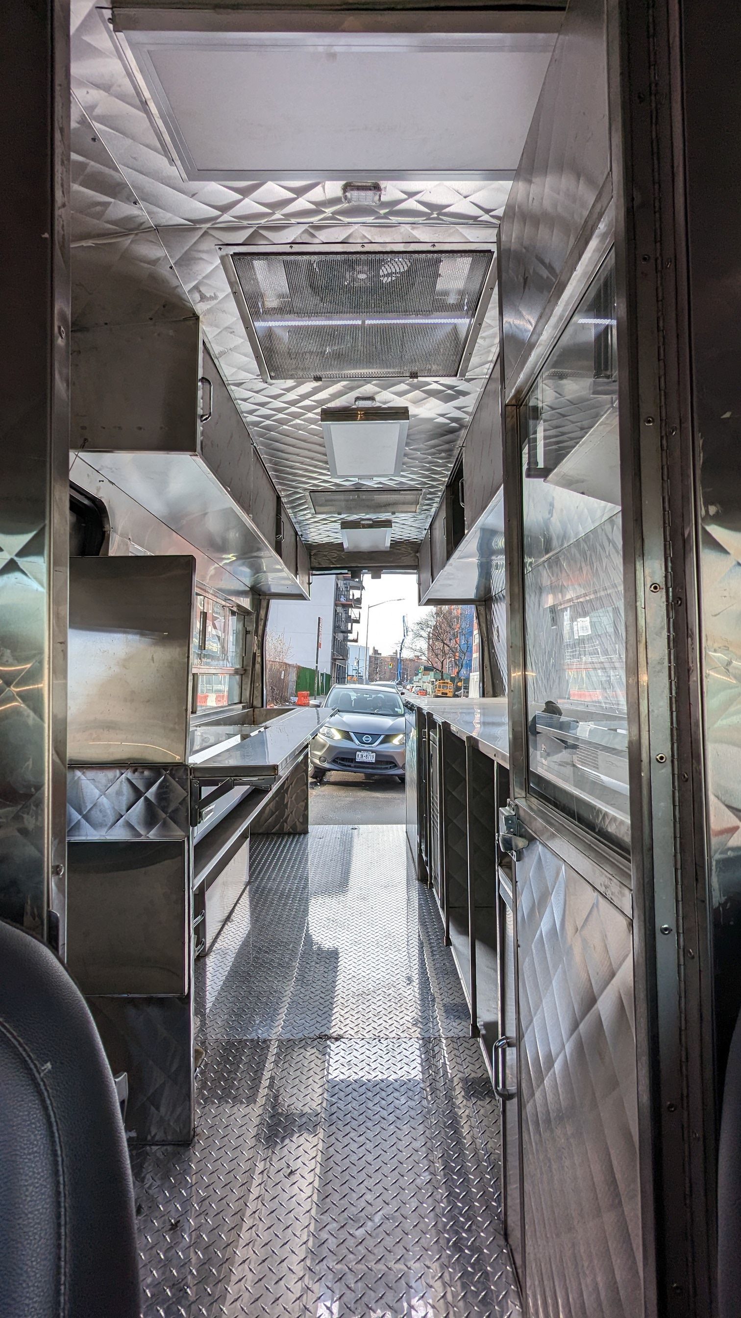 The inside of a food truck with a car parked in the background.