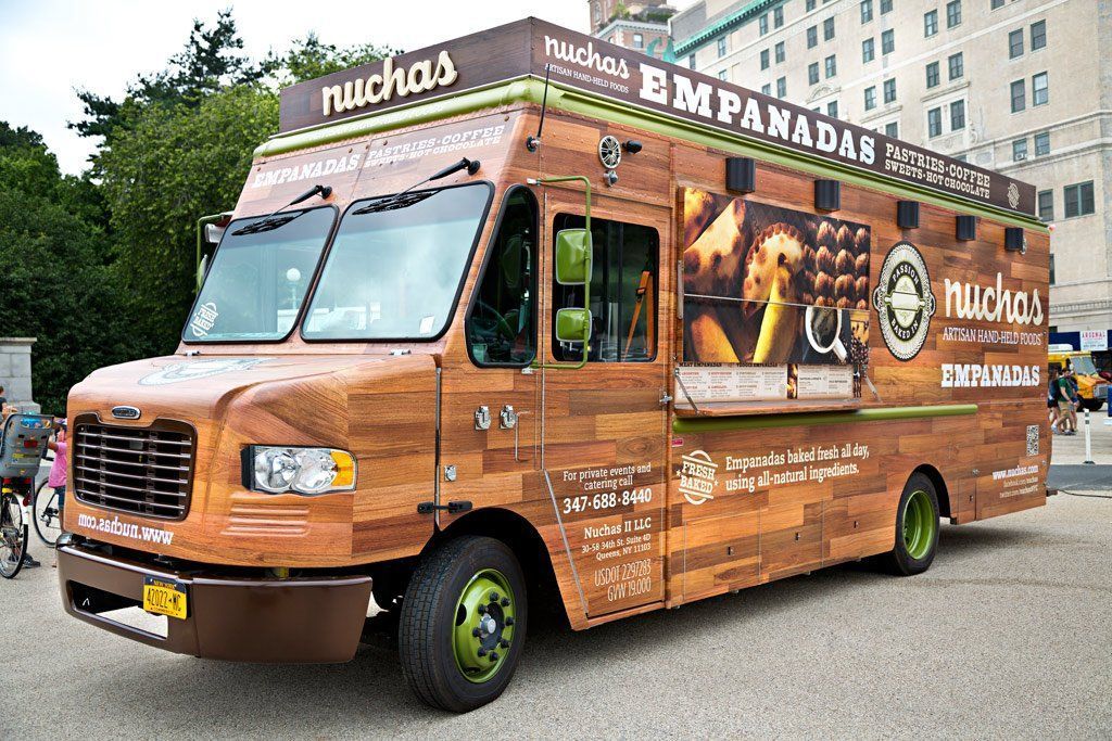 A food truck is parked in front of a building.