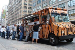 A tiger print food truck is parked on the side of the road.