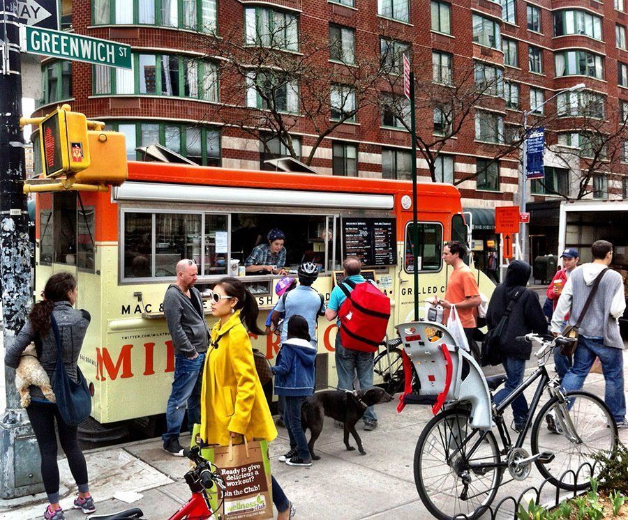 A group of people are standing in front of a food truck on greenwich street