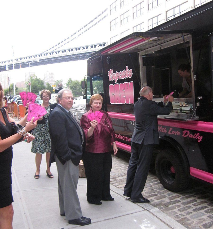 A group of people standing in front of a van love daily food truck