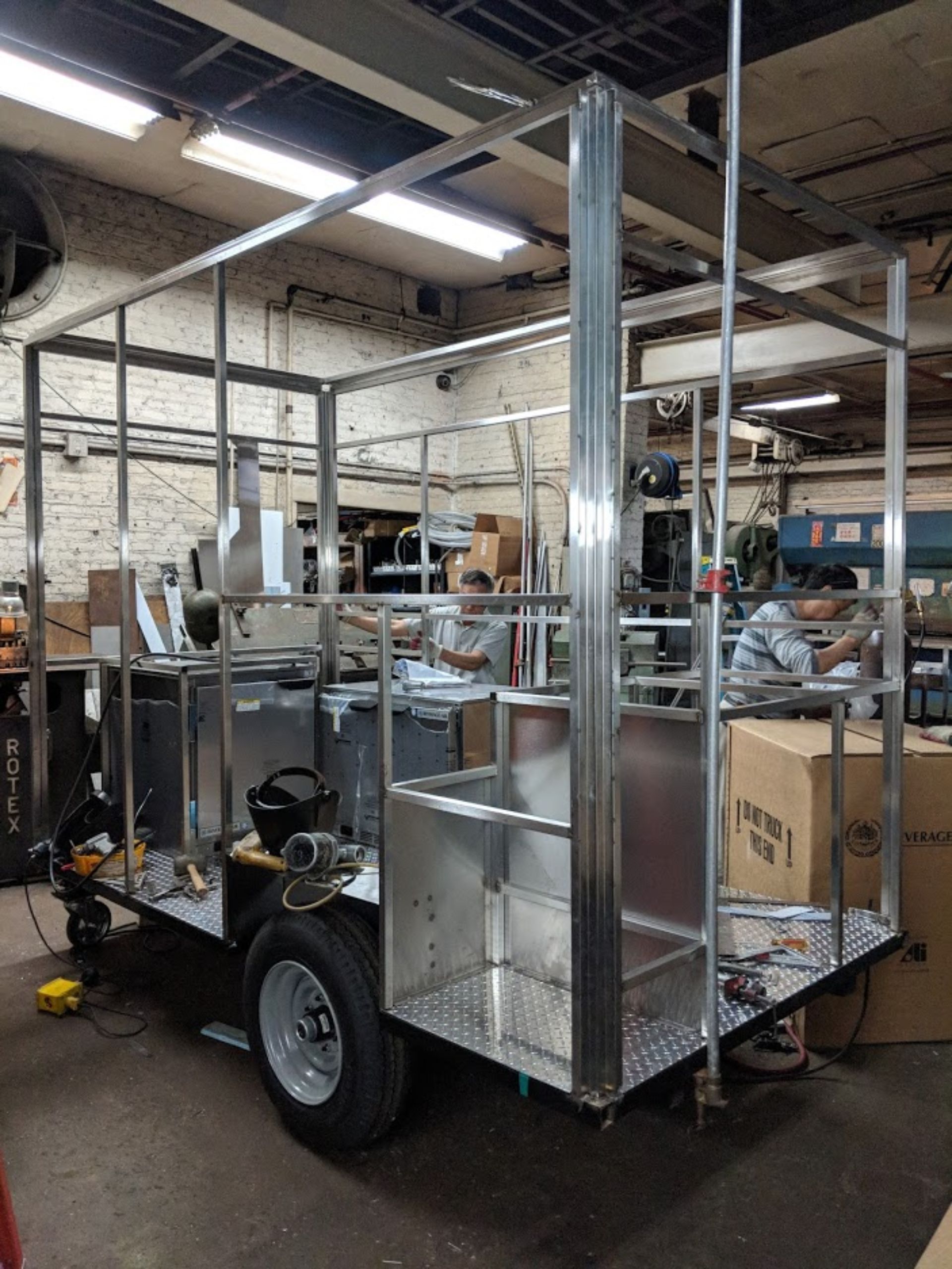 A stainless steel trailer is being built in a factory