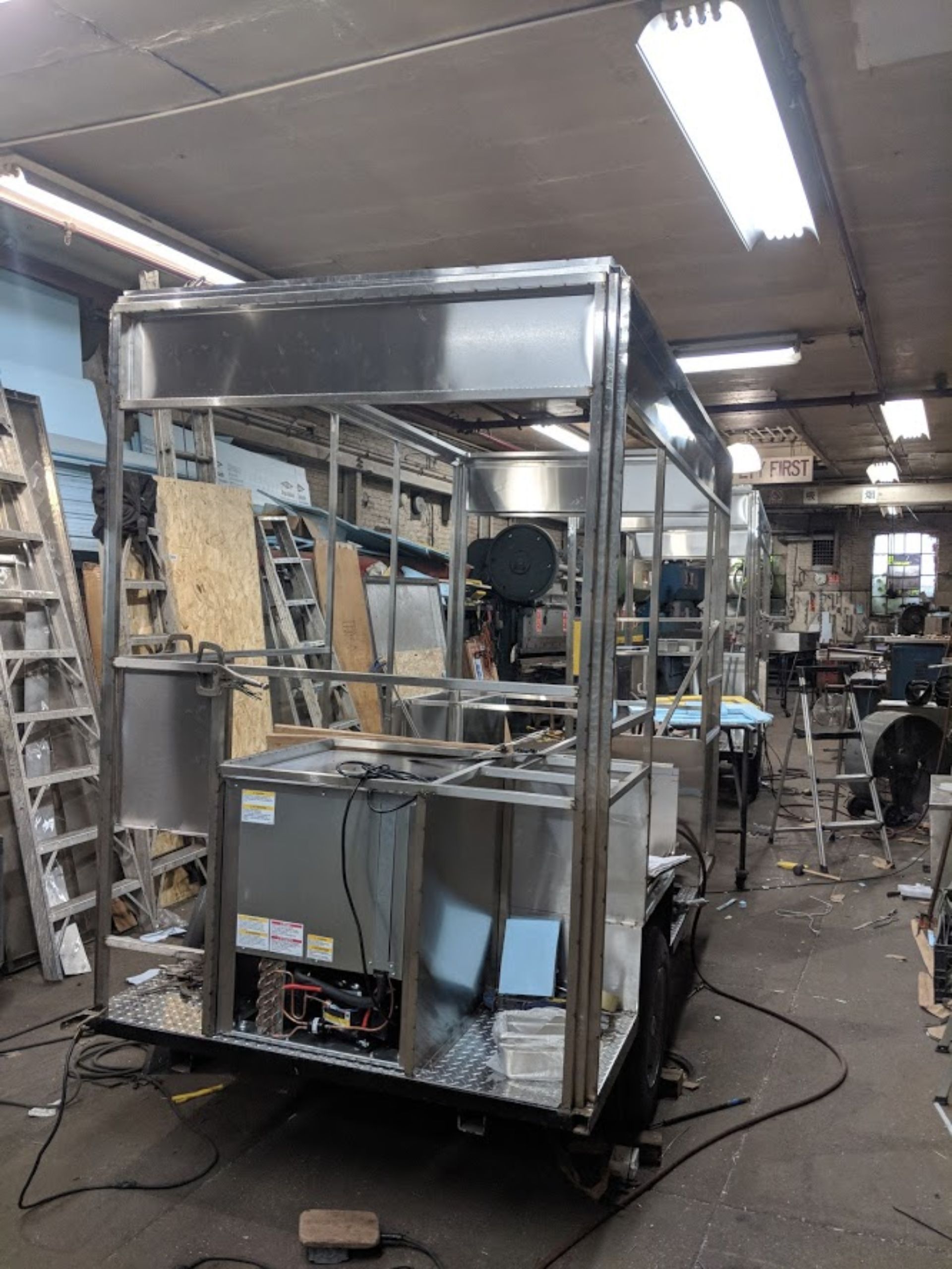 A stainless steel trailer is being built in a factory.
