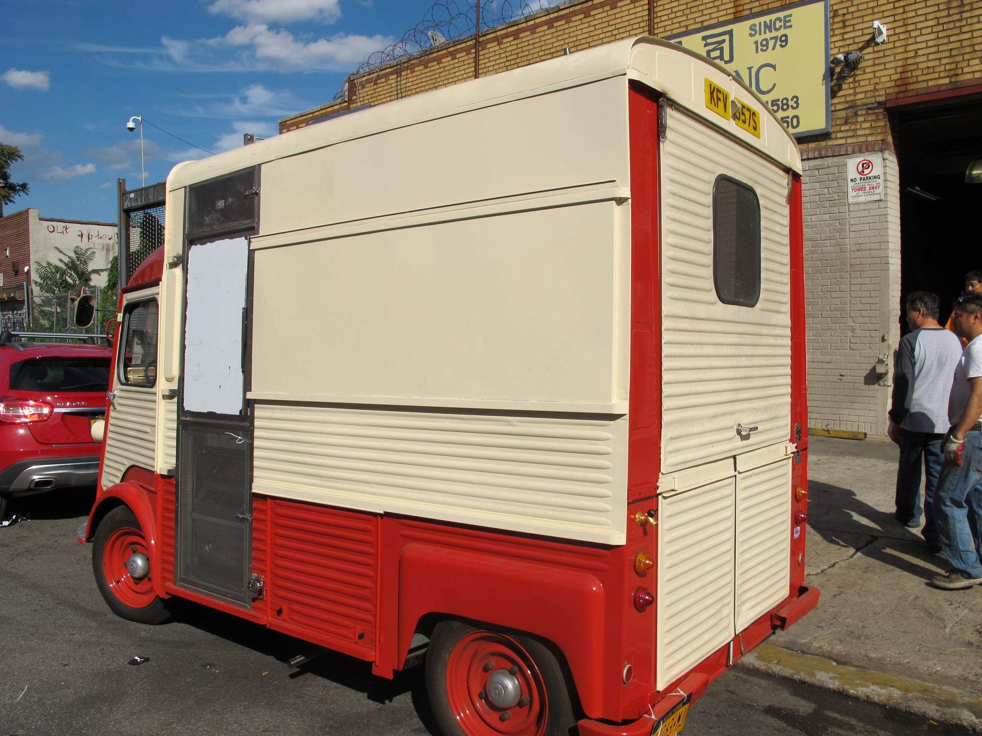 A red and white food truck is parked on the side of the road