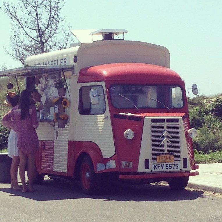 A red and white food truck with the license plate kfv 5575