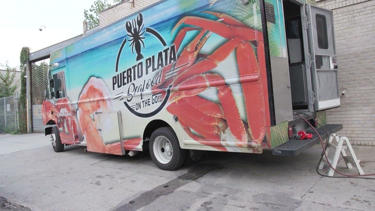 A puerto plata food truck is parked on the side of the road.