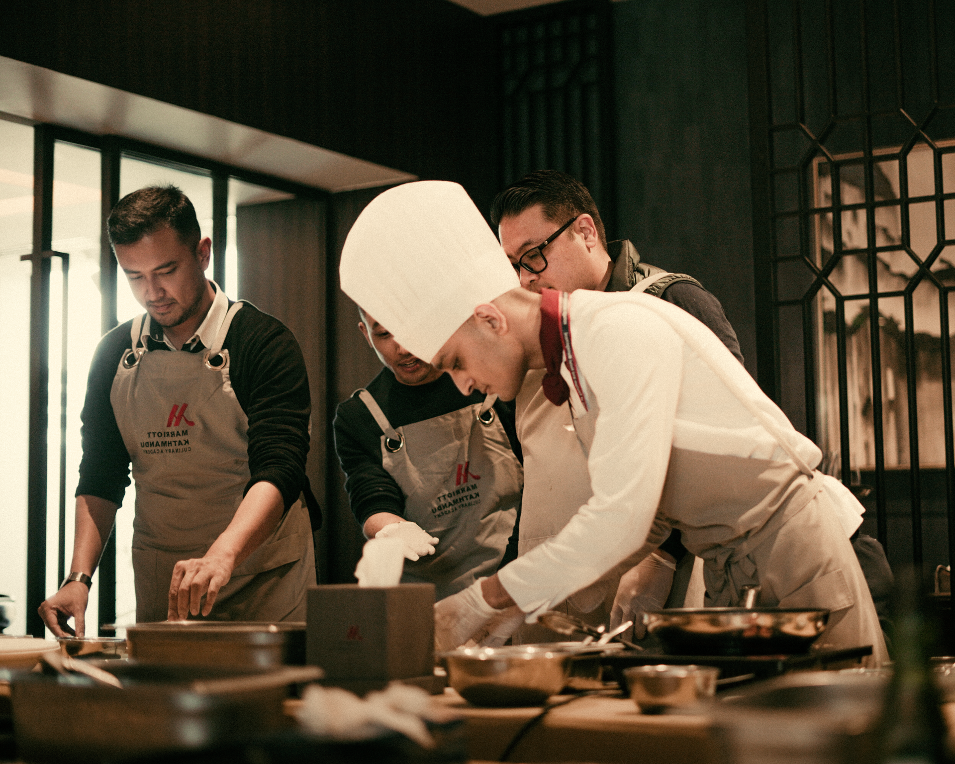 A group of chefs are preparing food in a kitchen.