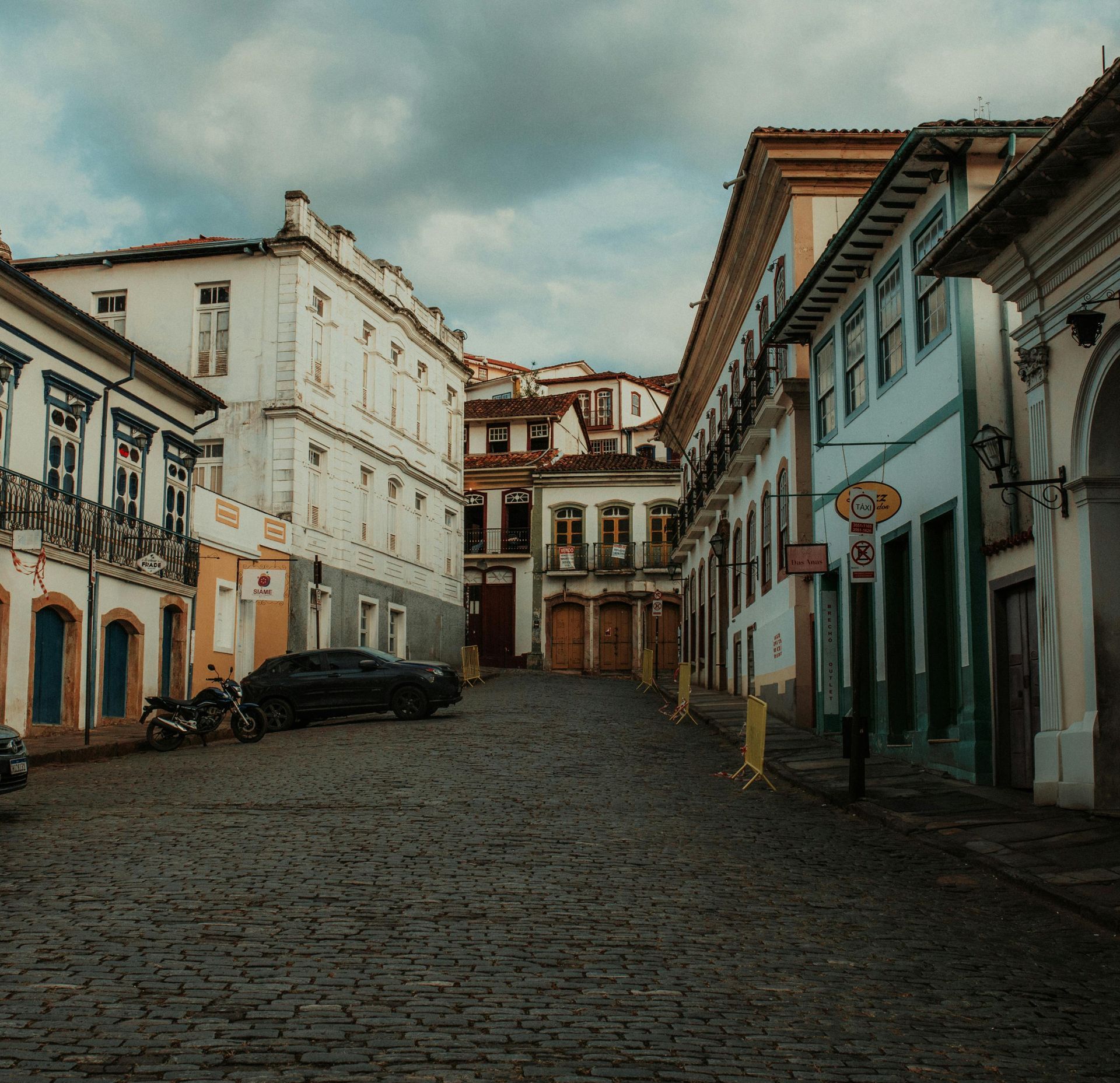A cobblestone street with a no parking sign